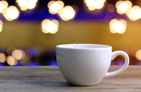 咖啡店木制桌上的白咖啡杯背景图片