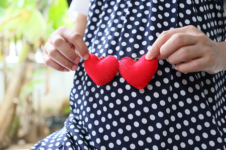 孕妇穿着孕妇装肚子上有红心符号背景图片