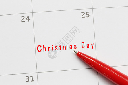 红笔指向日历背景上的圣诞日文字并有25号文字用于设计您的工作概念图片