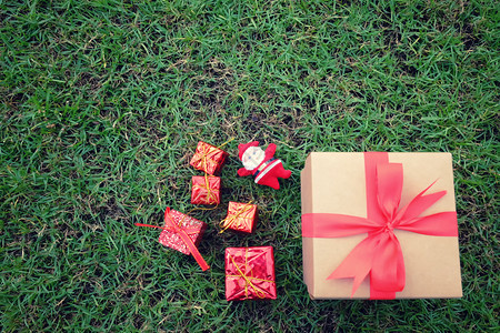 圣诞新年情人节或周纪念日绿色草坪上的礼品盒背景图片