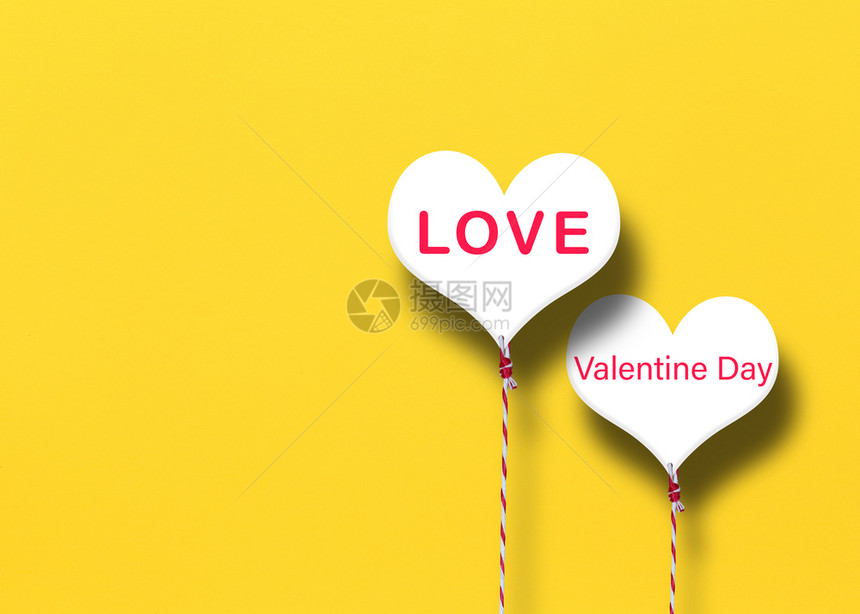 在黄纸背景上写着爱与情人节概念的白心图片
