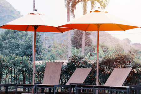 空的野外椅子和大型伞保护太阳在度假村图片