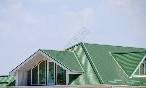 有塑料窗和绿色瓦楞板屋顶的房子屋顶金属型材波浪形的房子与塑料窗波纹金属型材和塑料窗的绿色屋顶有塑料窗和绿色瓦楞板屋顶的房子绿色屋背景图片