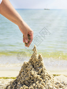 在夏天的沙滩上用湿海建造一座城堡关闭图片