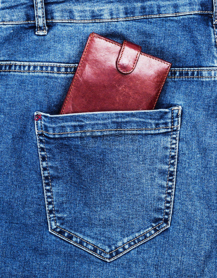 棕色皮包躺在蓝牛仔裤的后袋里图片
