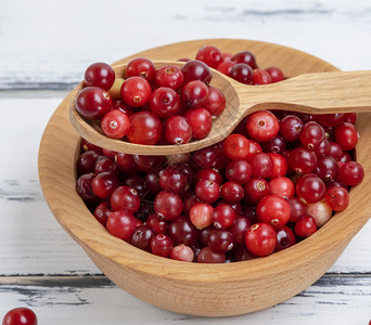 红色的莓成熟林贡在一个木碗白桌子上的木碗图片
