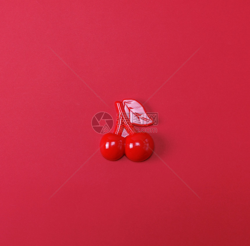 红色背景的塑料儿童玩具樱桃图片