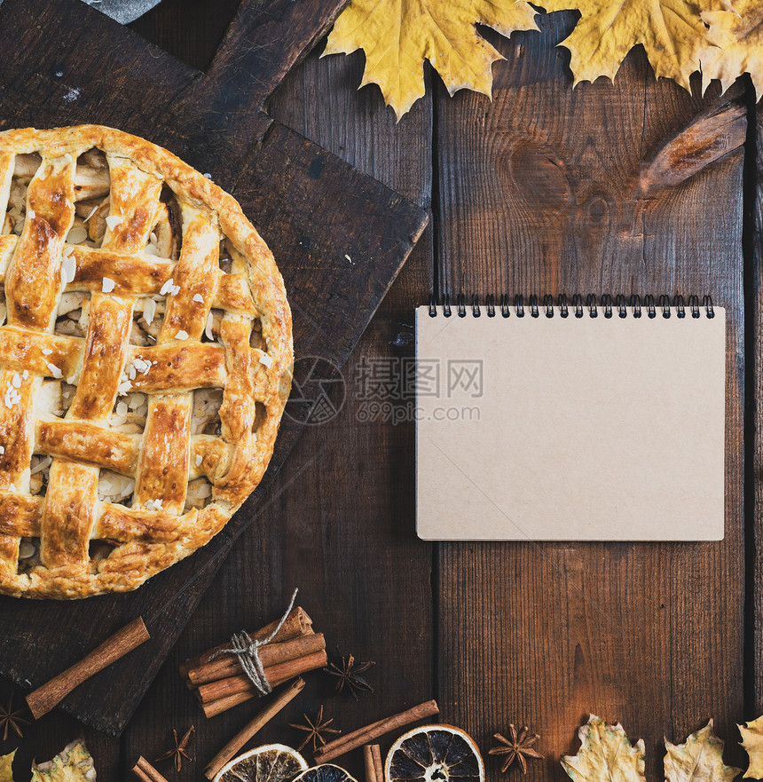 纸板上的烤苹果派和一张笔记本上面有空白页用于写食谱旧式调制复空间图片