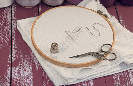 木制刺绣框架的白织物缝合针木制破旧桌刺绣圆圈的一串线条图片