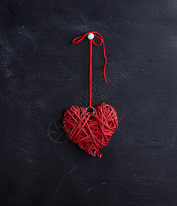 红心的小 挂在一根绳子上 面对黑色背景图片