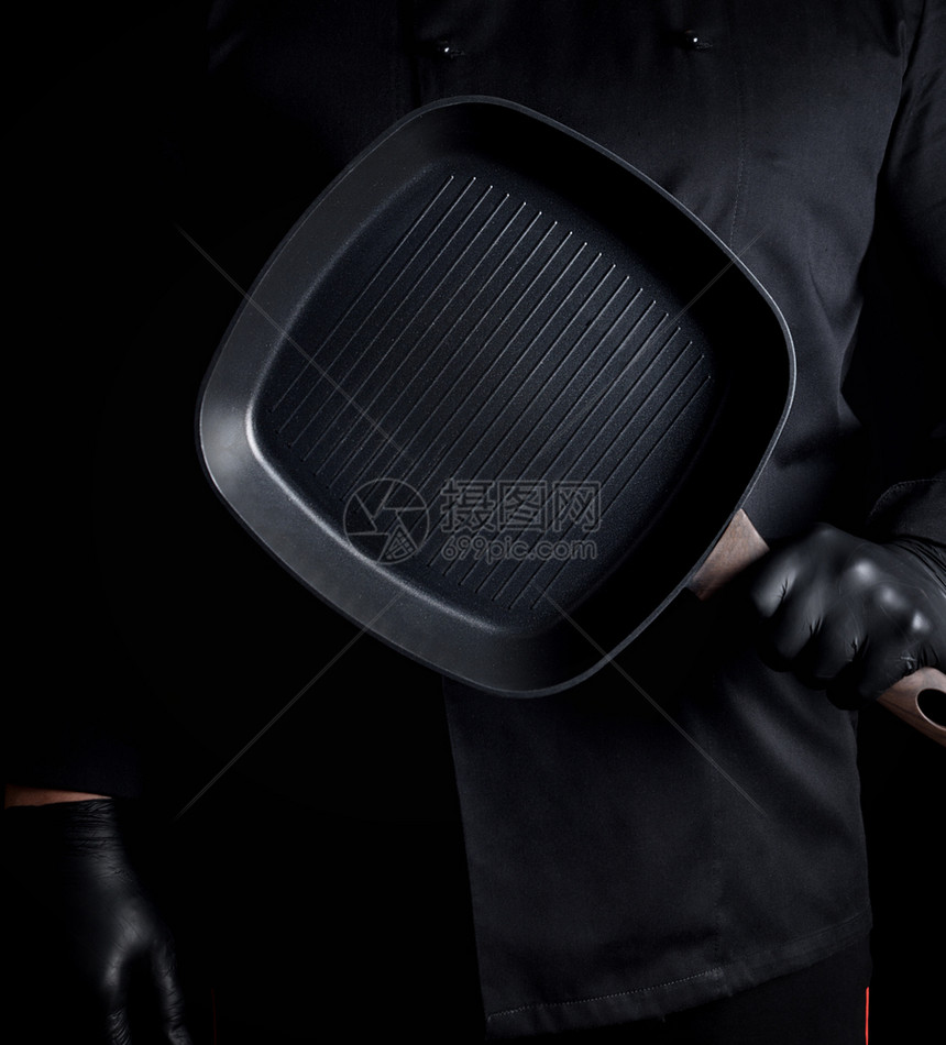 黑衣和乳胶大厨手套带有黑色背景的空方格烧烤锅图片