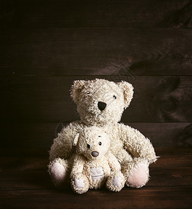 两只老棕色软泰迪熊坐在木表面图片