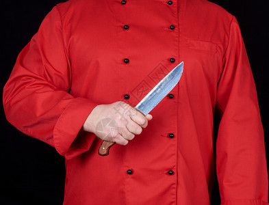 穿红制服的厨师右手拿着一把厨房刀黑色背景图片