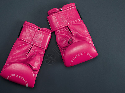 黑色背景顶视面的新型粉色运动拳击手套背景图片