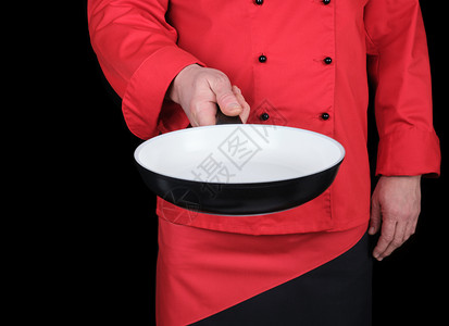 身穿红衣厨服手持空圆白煎锅黑色背景图片