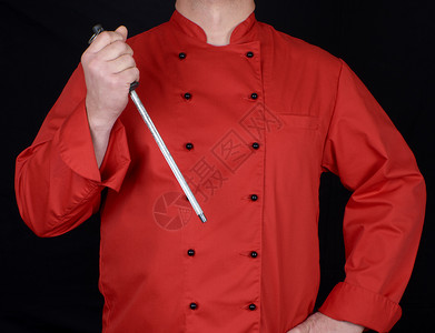 穿红制服的厨师拿着刀尖磨工具黑色背景背景图片