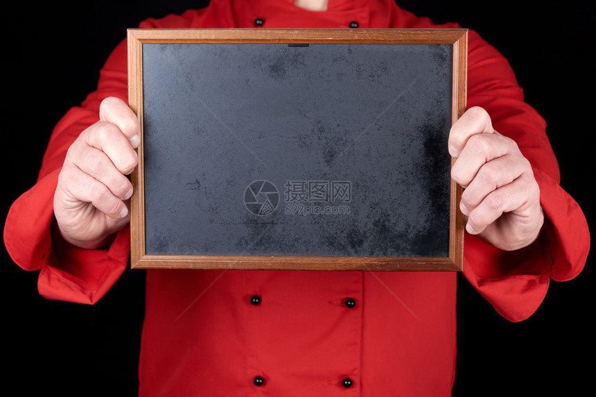 穿红制服的厨师拿着黑色背景的空木框关上图片