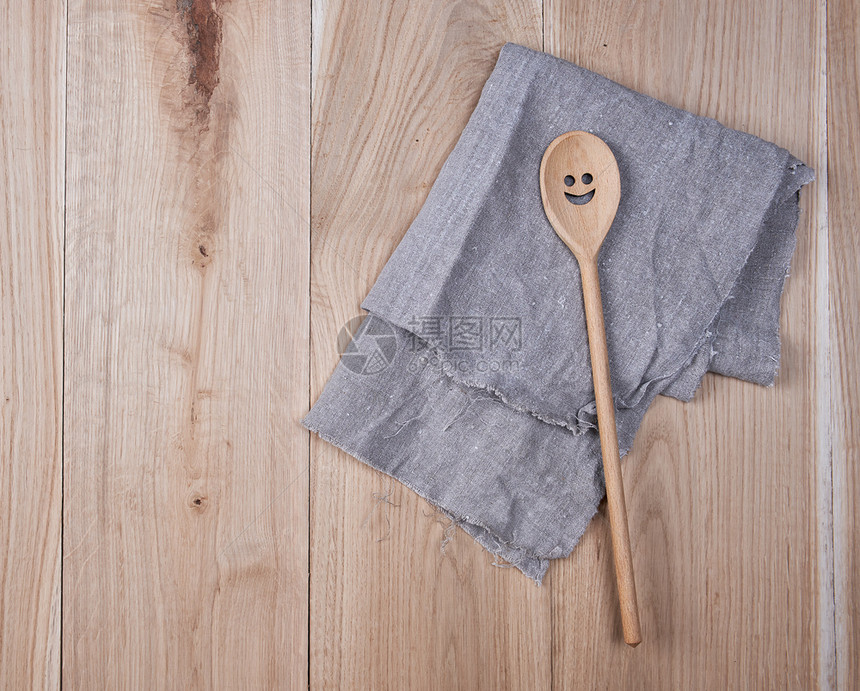 棕色木背景顶视图的灰色毛巾和勺子折叠灰色毛巾图片