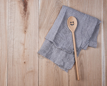 棕色木背景顶视图的灰色毛巾和勺子折叠灰色毛巾图片
