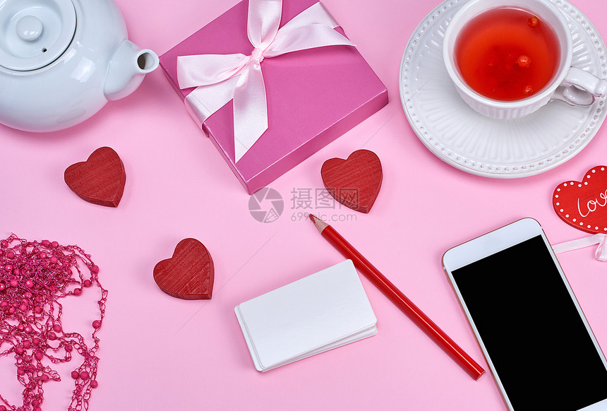 白纸名片智能手机和粉红背景的草药茶顶视图图片