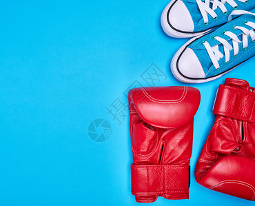 红色拳击手套和蓝纺织运动鞋顶视图复制空间背景图片
