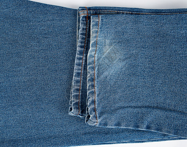 白色背景的蓝折叠牛仔裤碎片背景图片