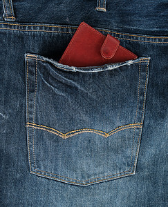 蓝牛仔裤后口袋的棕色皮钱包全框背景图片