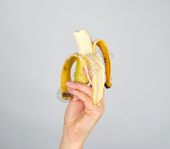 白底的雌手切开新鲜香蕉水果被咬掉图片