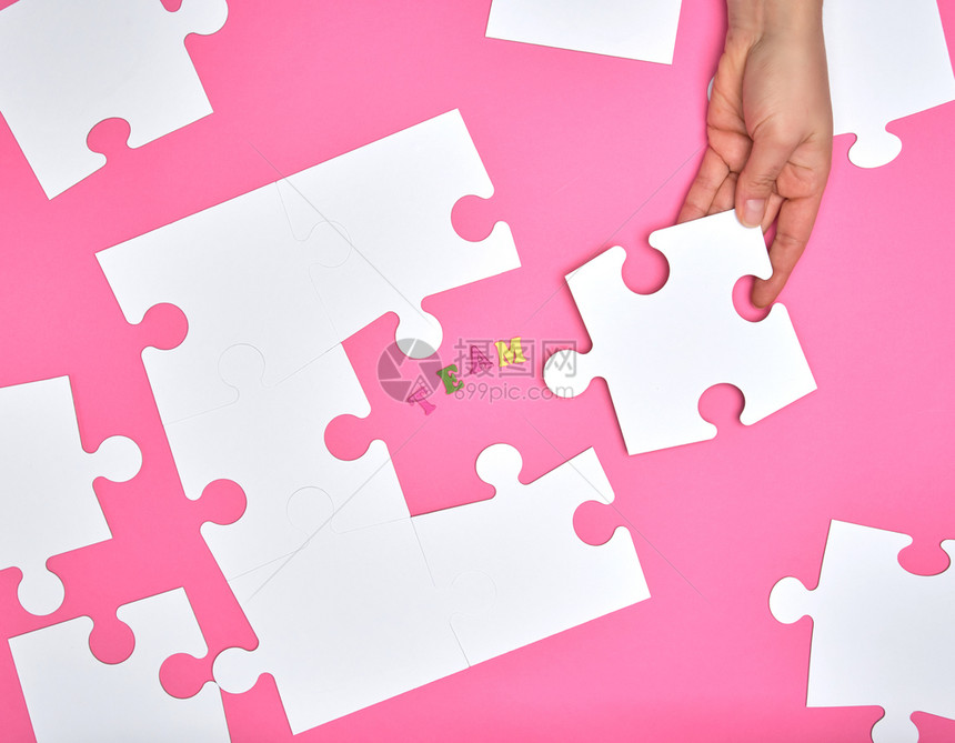 女手在粉红色背景上将白大谜题放在一个粉红背景上注册团队公司招聘概念图片