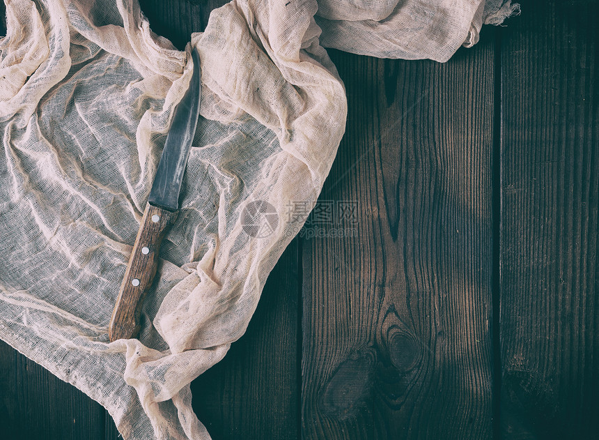 旧尖刀和木柄放在灰色的纺织纸巾上棕色的木本底顶视图复制空间图片