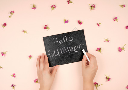 黑色粉笔框上面有刻着喜好夏天和两只女手上面有白色粉笔背景图片