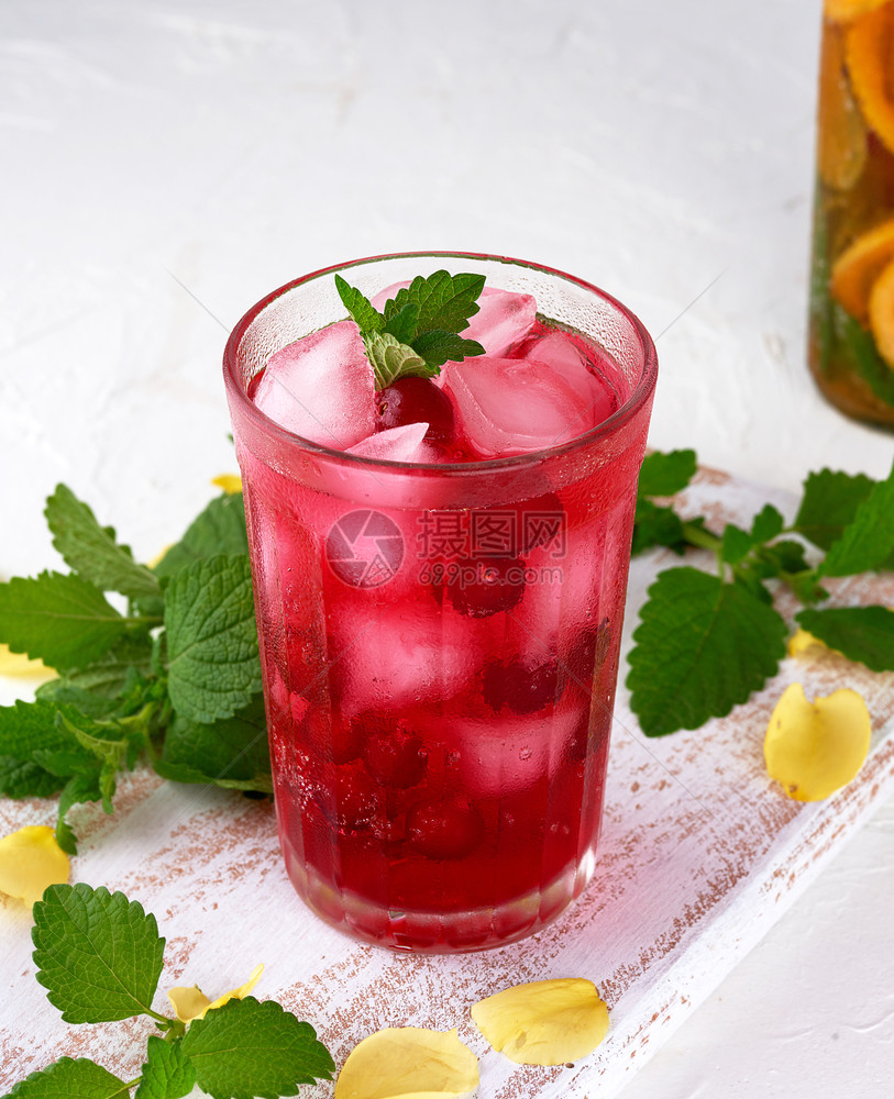 夏季清新饮料用红莓浆果和冰块在一木板上的玻璃杯中白底图片