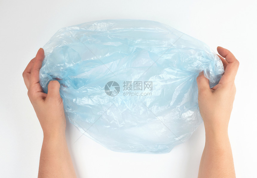 女手中的蓝色塑料垃圾袋白色背景顶视面图片