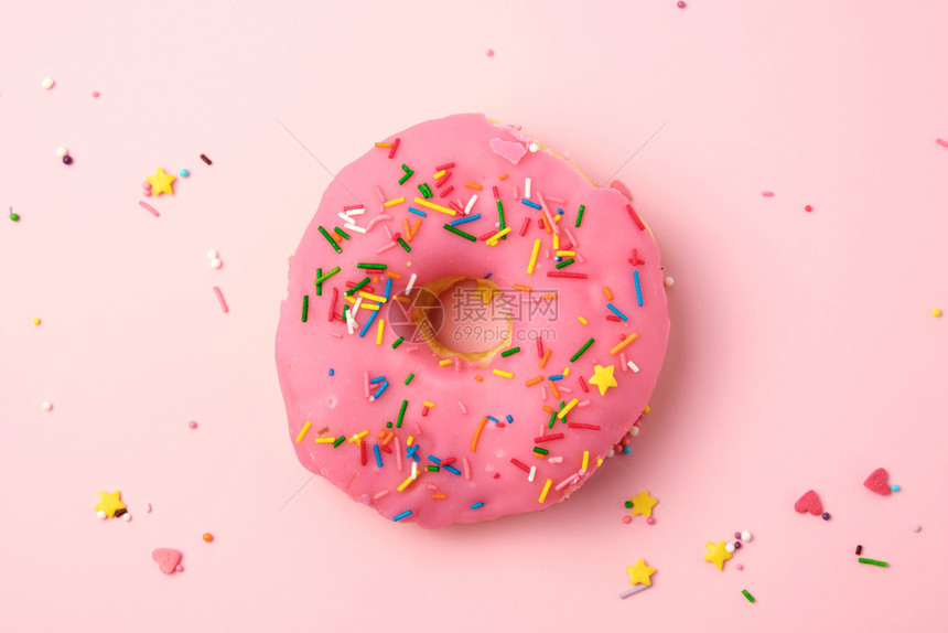 粉红色圆甜圈上观在面纸背景上喷洒彩色图片