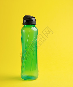 黄色背景的封闭塑料绿色透明运动瓶关闭图片