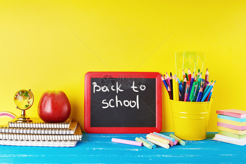 黑色粉笔架和学校用品蓝背景概念返回学校图片