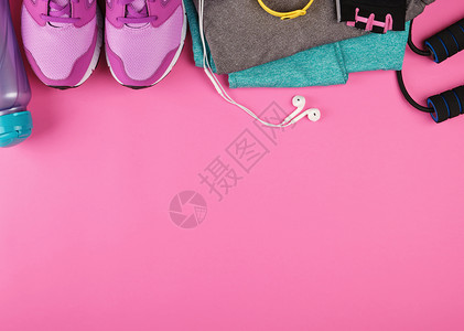 粉红妇女运动鞋一瓶水手套和跳绳用于粉红背景顶视复制空间平铺运动图片