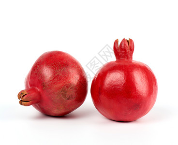 两块成熟的红石榴在白色背景的皮上关闭背景图片