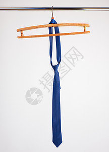 蓝色领带挂在木衣架上白色背景图片