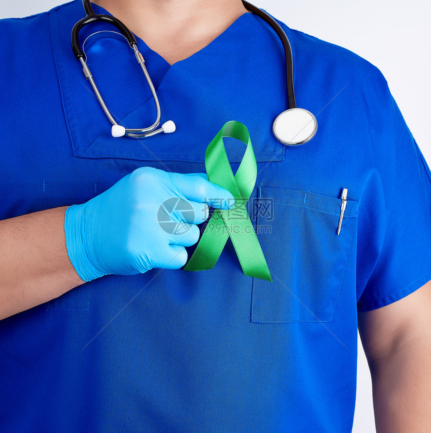 蓝制服和乳胶手套医生戴绿丝带作为早期研究和疾病控制莱姆肾移植和器官捐赠的象征图片
