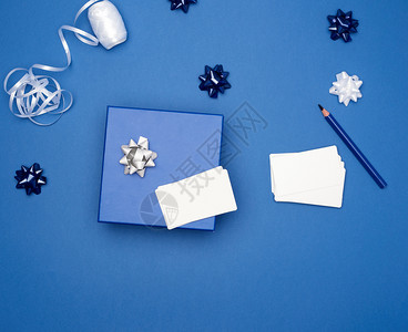 封闭式纸板礼品箱弓深蓝色背景包装带顶视图趋势颜色背景图片
