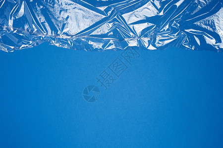 为包装产品在蓝底全框架闭合的包装产品制作透明拉伸塑料薄膜的纹理图片