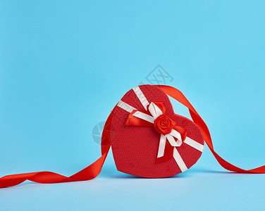 红色心形礼物盒蓝色背景的红弓顶部视图节日背景情人礼物图片