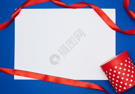 蓝色背景测试地点假日背景上的白纸和红色丝绸带背景图片