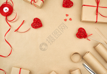 拼团有礼棕色Kraft纸包装的礼品袋和绑有红丝带心一套用于礼品制作的物礼包装件设计复制空间背景