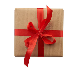 方形框用棕色克拉夫纸包着绑有丝绸红色带顶视图白色背景的礼物背景图片