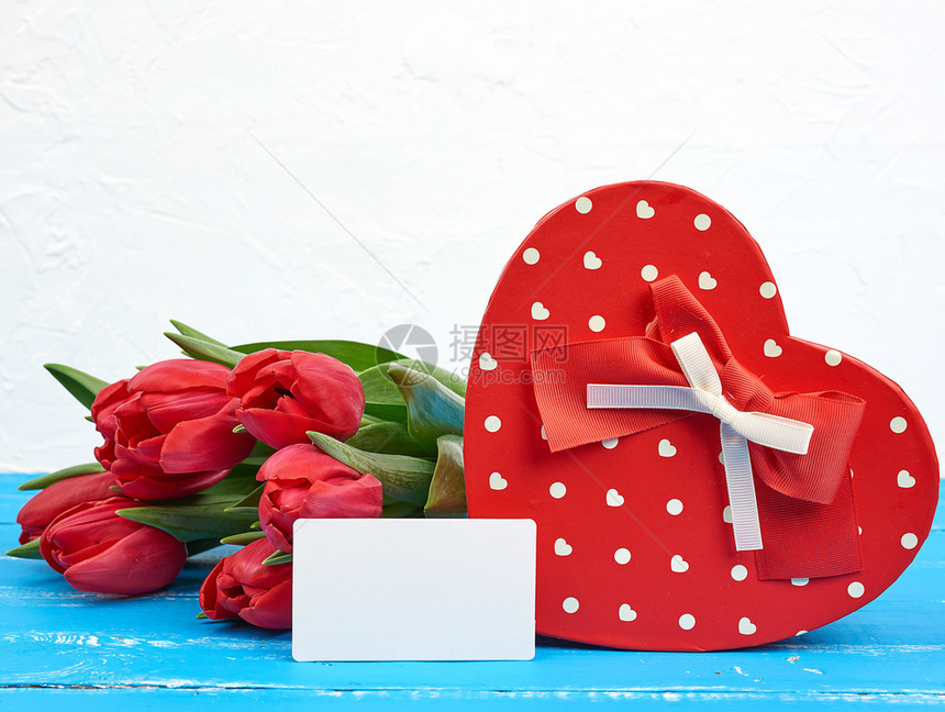 空长方形白纸名片红色郁金香包和蓝木背景的心形纸板盒生日情人节周年纪念的喜好背景图片