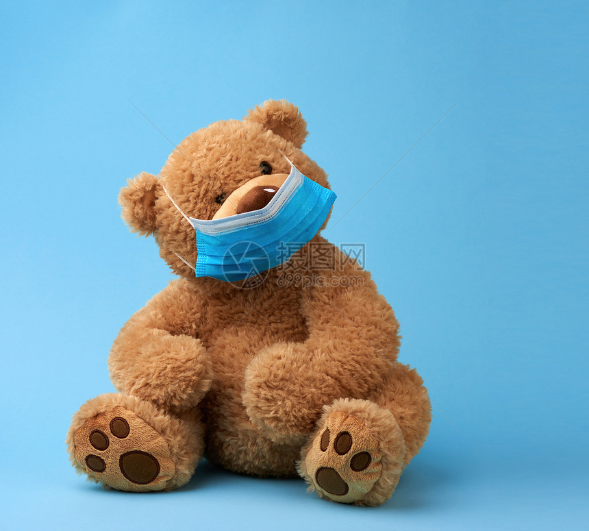 大泰迪熊蓝面罩底保护免受呼吸道疾病毒和个人呼吸道保护的概念图片