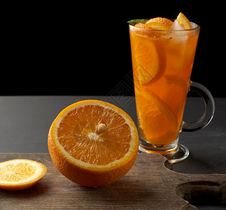 大杯手柄装满柠檬汁橙和黑底图片