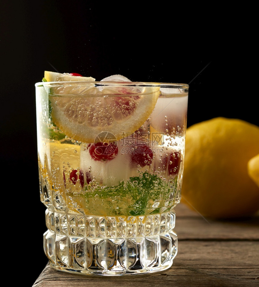 含柠檬汁冰块红莓黑色背景的清新夏季饮料透明杯子柠檬水和冰块图片